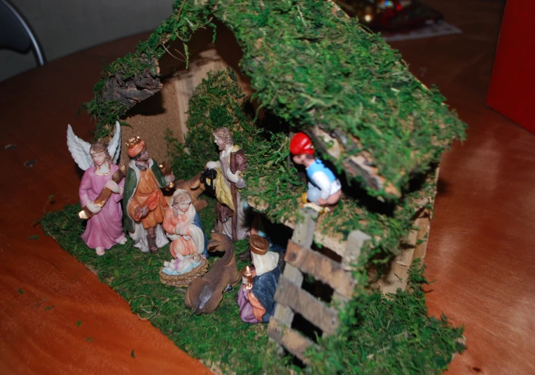 nativity scene displayed in fake house with red hat