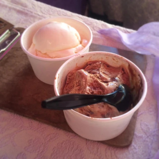 two bowls containing a spoon and ice cream