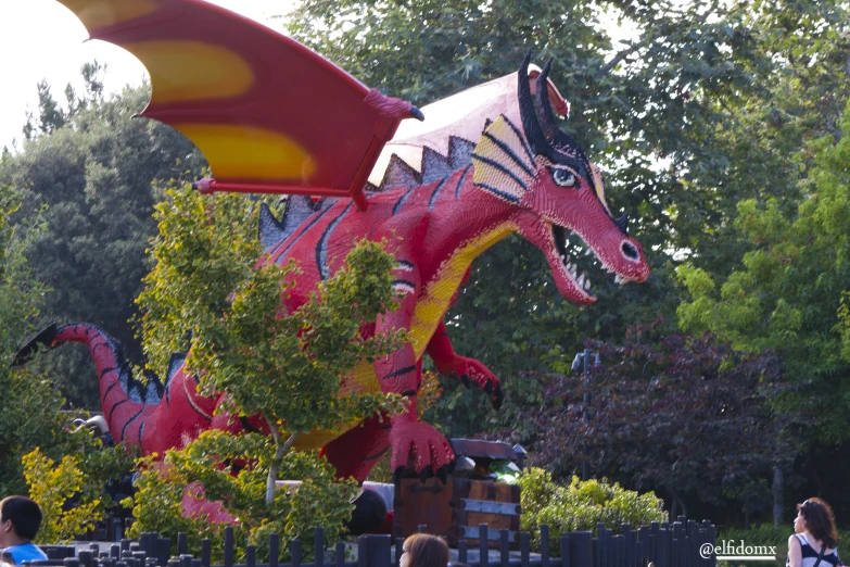 an inflatable dragon statue sitting on top of a tree