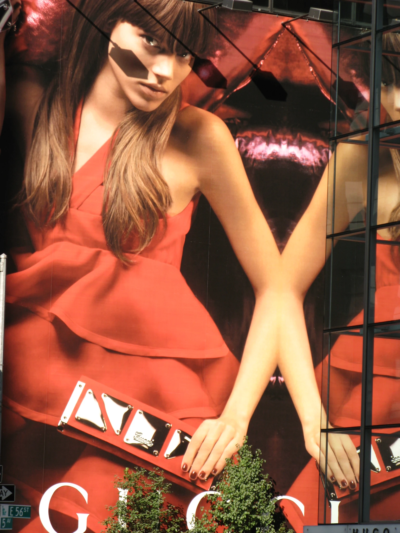 woman in red dress holding onto a large display of purses