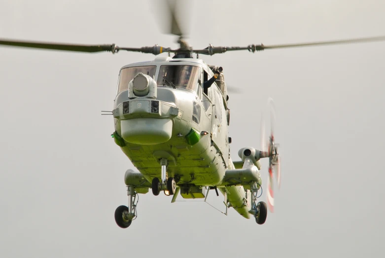 a helicopter flying through the sky with its pilot on board