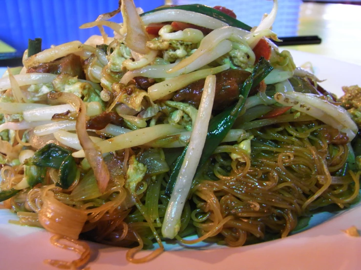 this dish features spaghetti, beef, onions, peppers and other vegetables