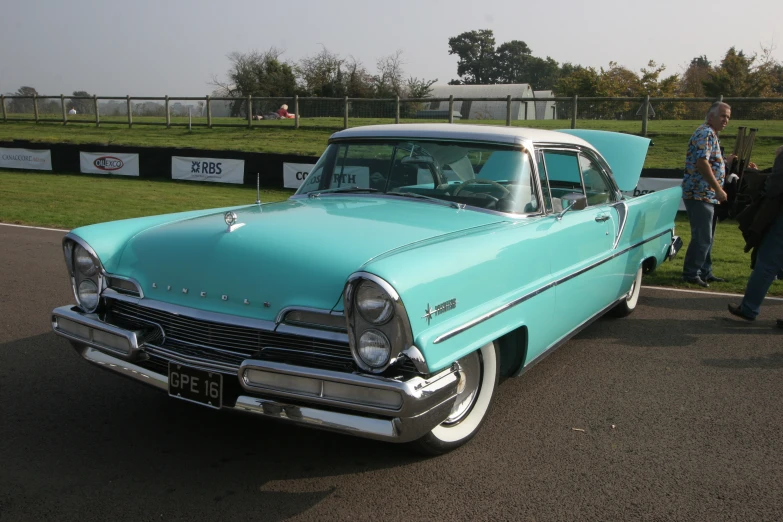 the back end of a blue classic car on a track