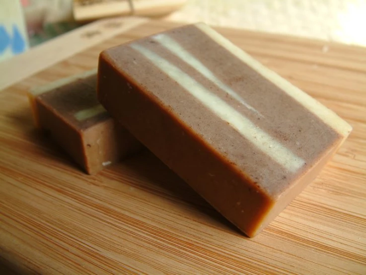 three pieces of brown soap on a wooden surface