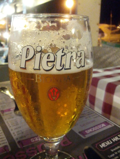the glass is full of beer and the label has pieberra written on it