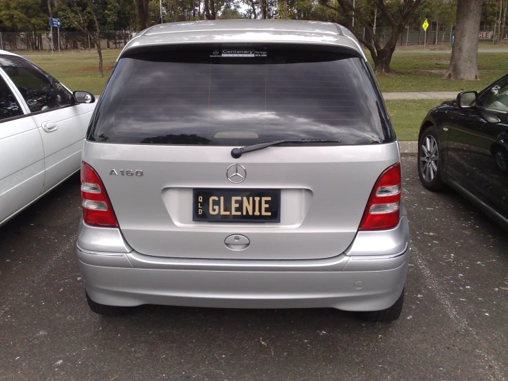 a silver mercedes parked next to a white honda