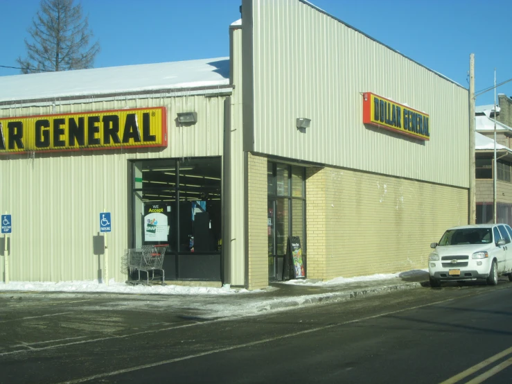 the outside of an industrial store with cars parked outside it