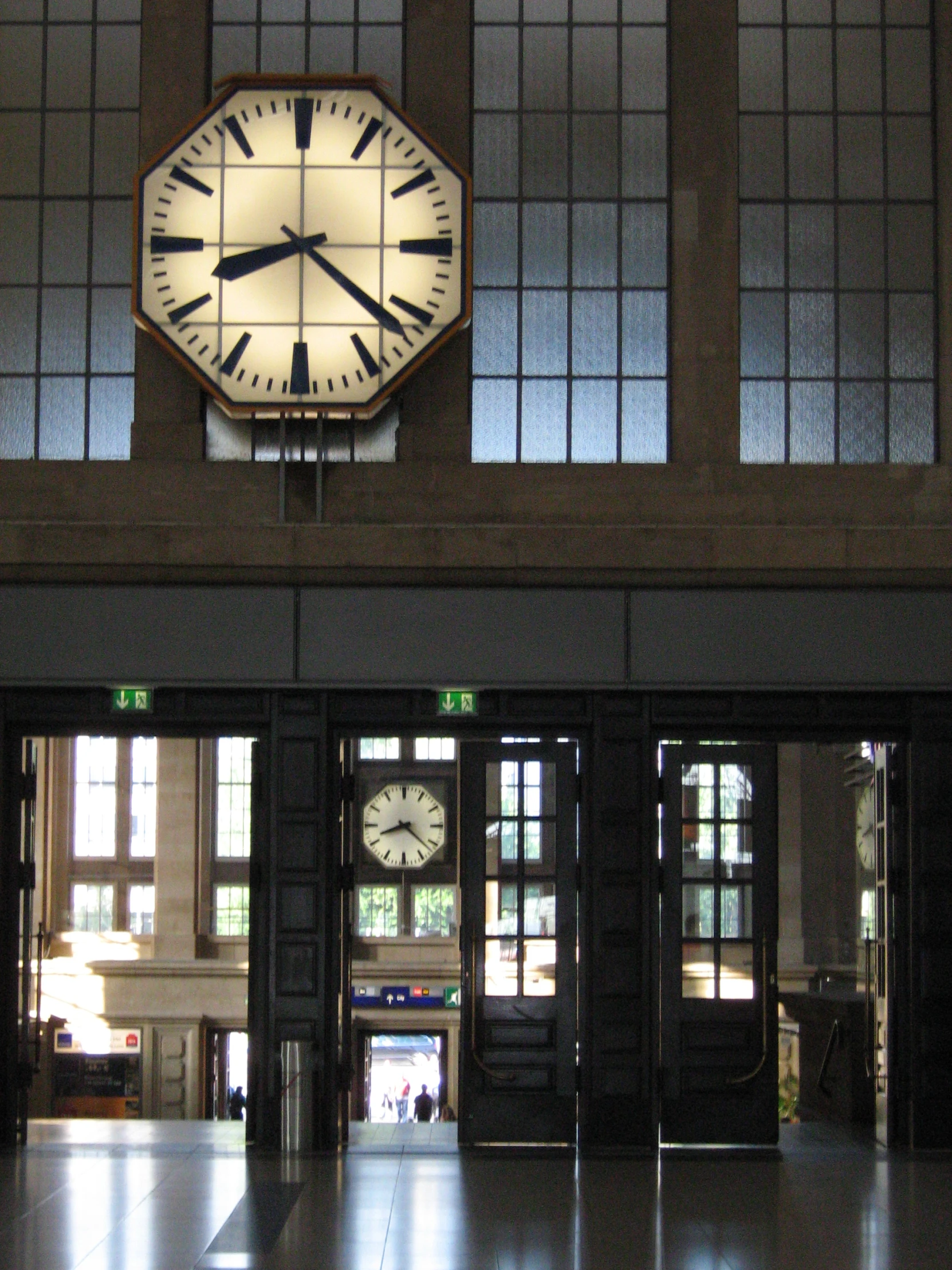 a view of the clock in a building with multiple windows