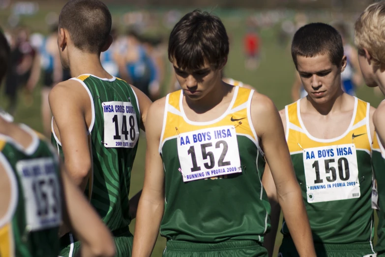 three young men in uniforms and numbers are walking