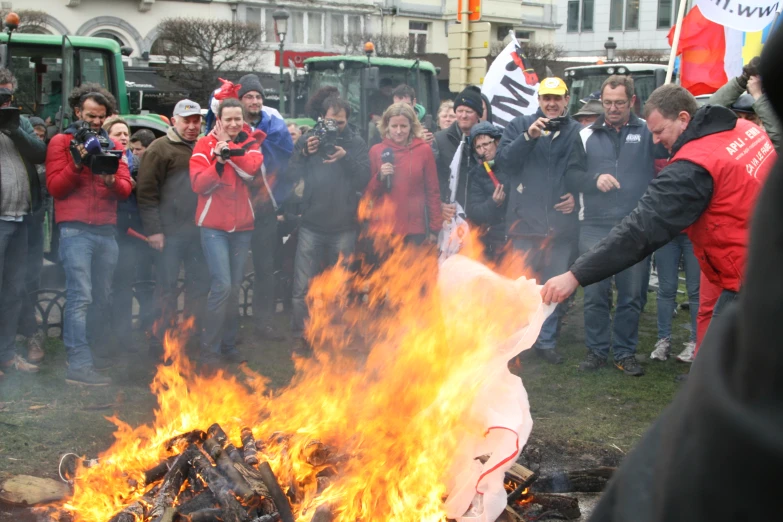 many people are gathered by a bonfire in the middle of the street