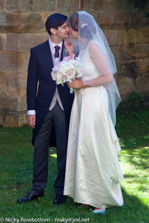 a newly married couple are posing for a po in front of a stone wall