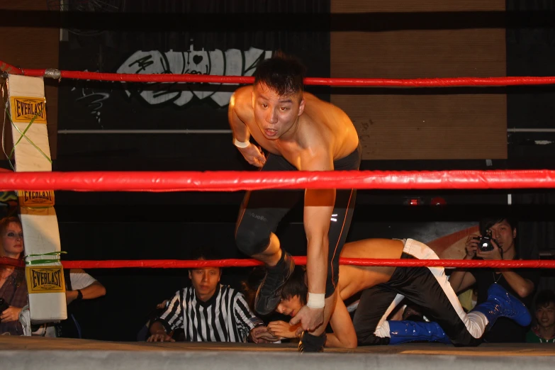 a wrestlers knee lifts him in mid air as others look on
