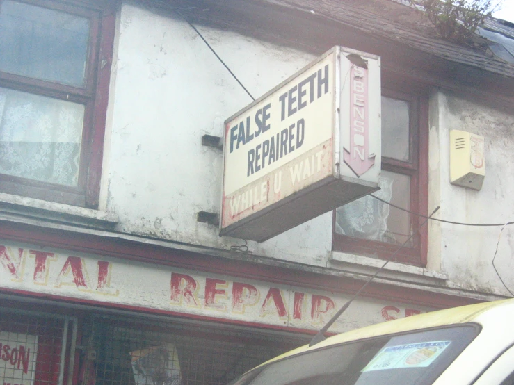 a fake teeth replaced sign on the outside of a shop