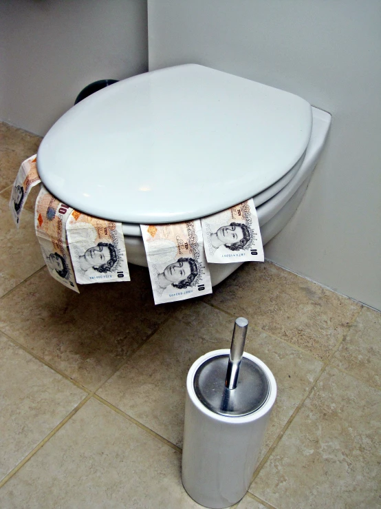 two rolls of cash sit next to a toilet