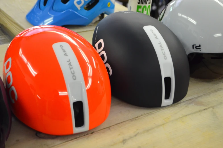 three different helmets lined up together on a table