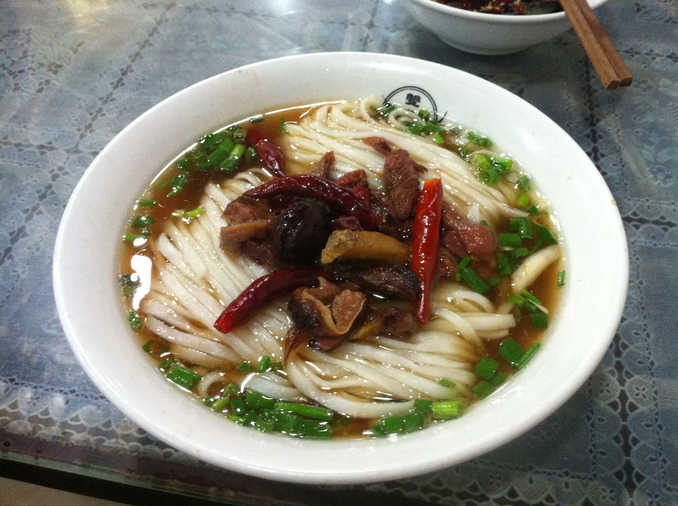 this is a bowl of soup with noodles and vegetables