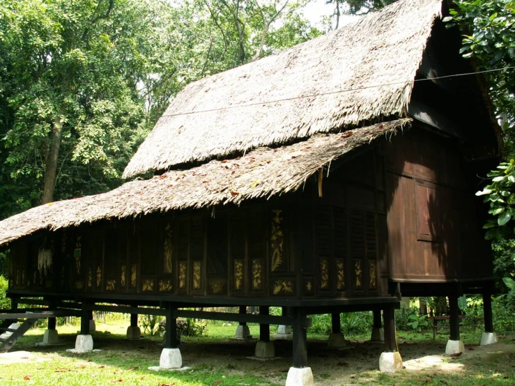 a large wooden house with a thatched roof
