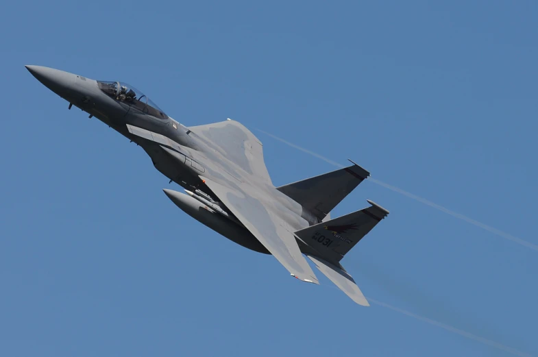 a fighter jet flying through the blue sky