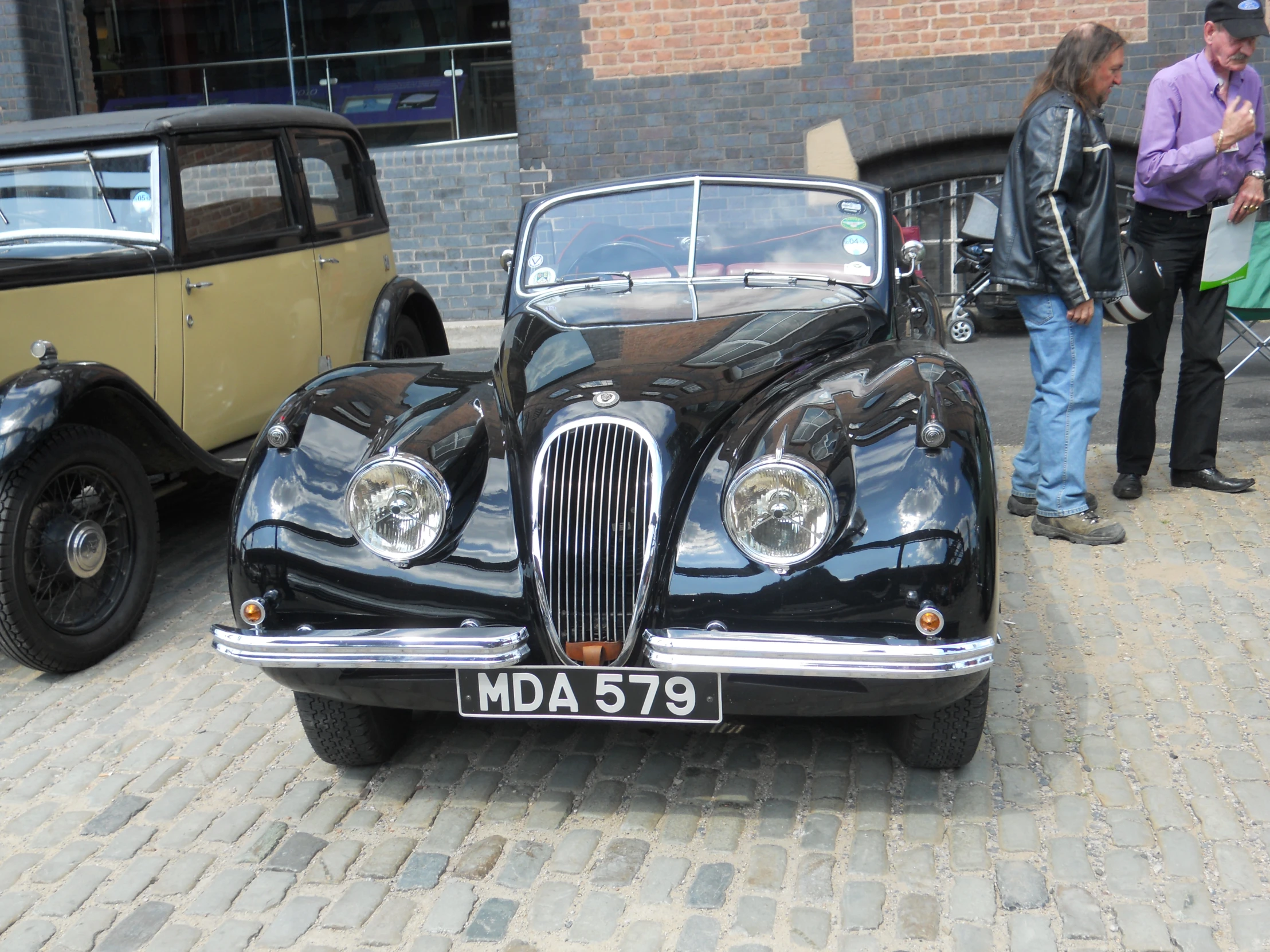 old black and tan cars on brick sidewalk