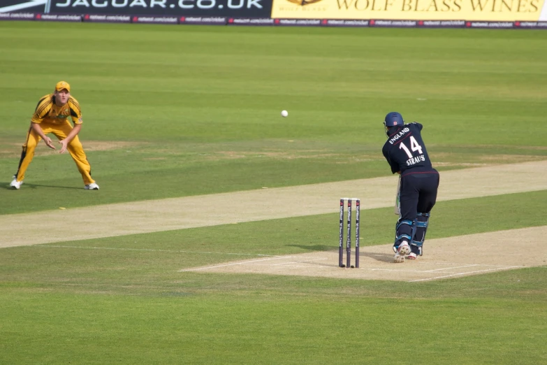 a female cricket player swinging a bat to hit the ball