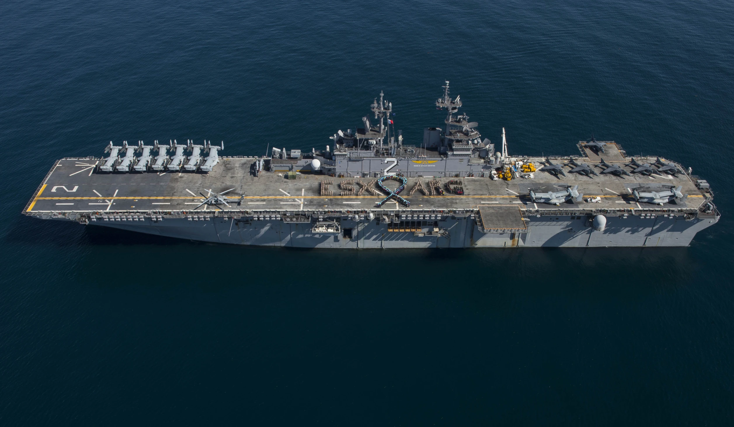 an aircraft carrier in the middle of a body of water