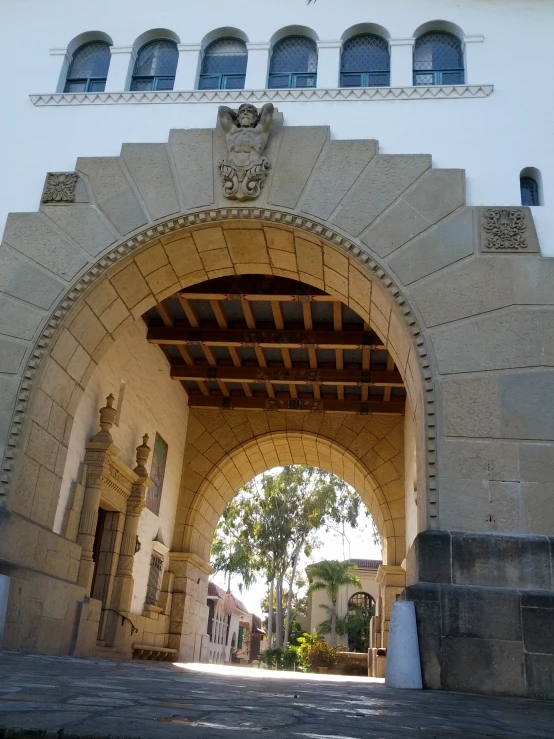 an archway leading to a building with a clock on the front