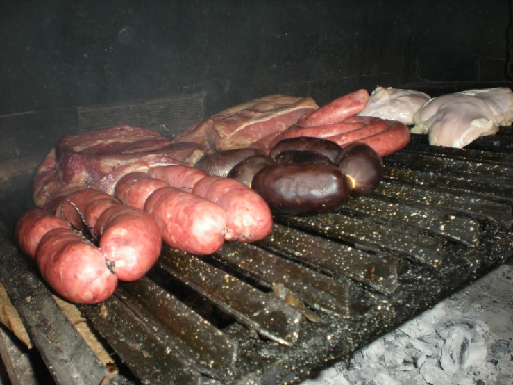 a bunch of sausages roasting on an outdoor grill