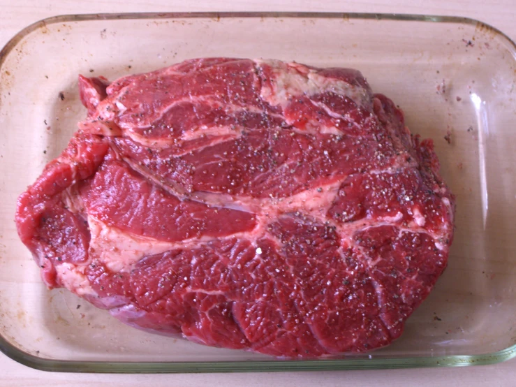 a raw meat piece on display in a glass dish