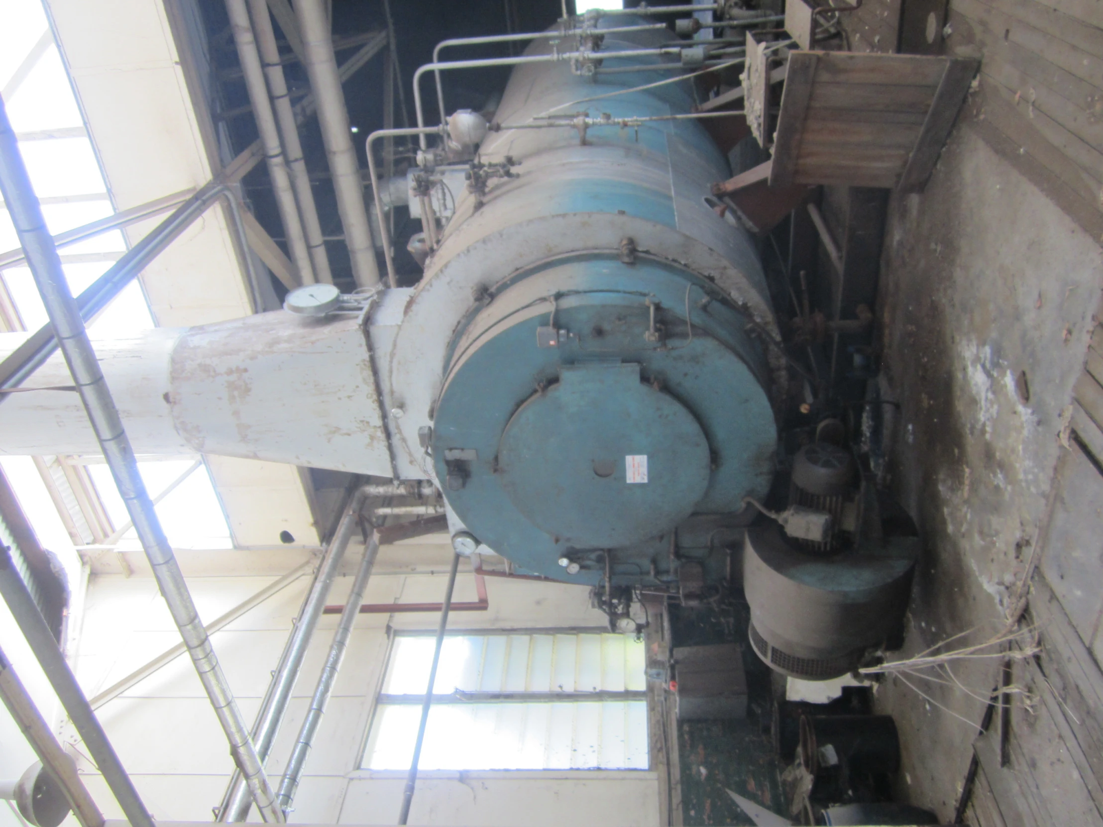 large white and blue steam engine in warehouse