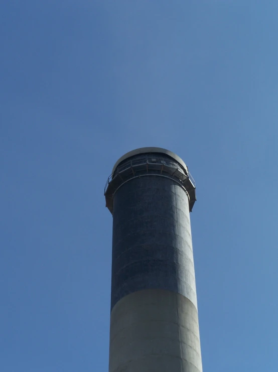 the tall gray tower against the blue sky