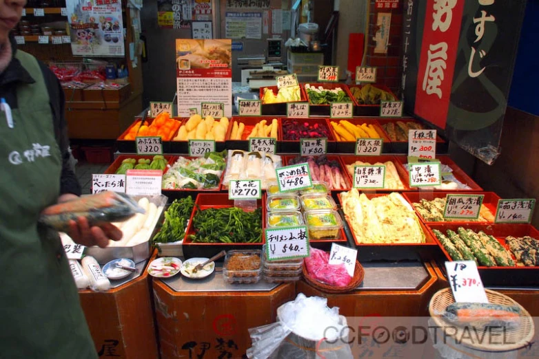 a vendor stands behind a produce display at a market