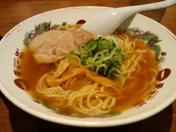 a close - up of a bowl filled with food on top of a wooden table