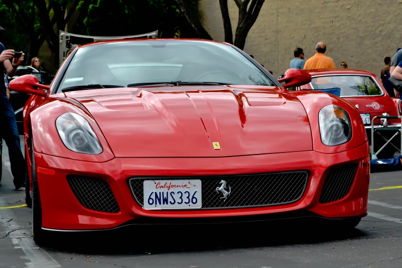 the front end of a red sports car at a festival