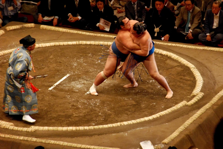 two sumo wrestlers are in a circular ring