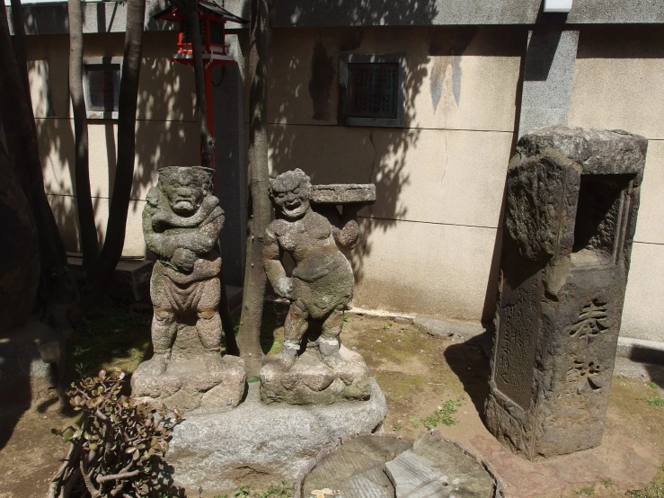 an outdoor garden features statues on rocks