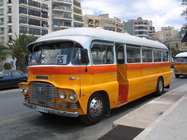 two old yellow buses parked next to each other on the street