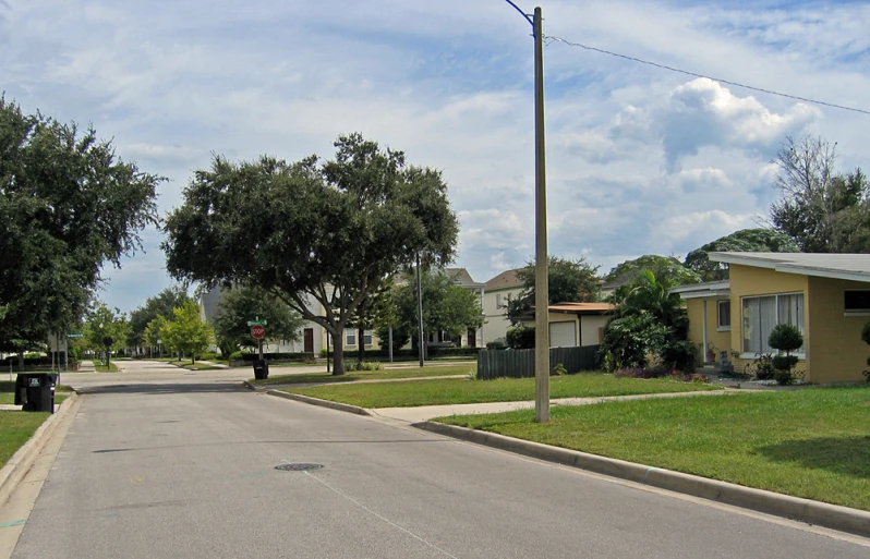 a residential neighborhood street with a telephone pole