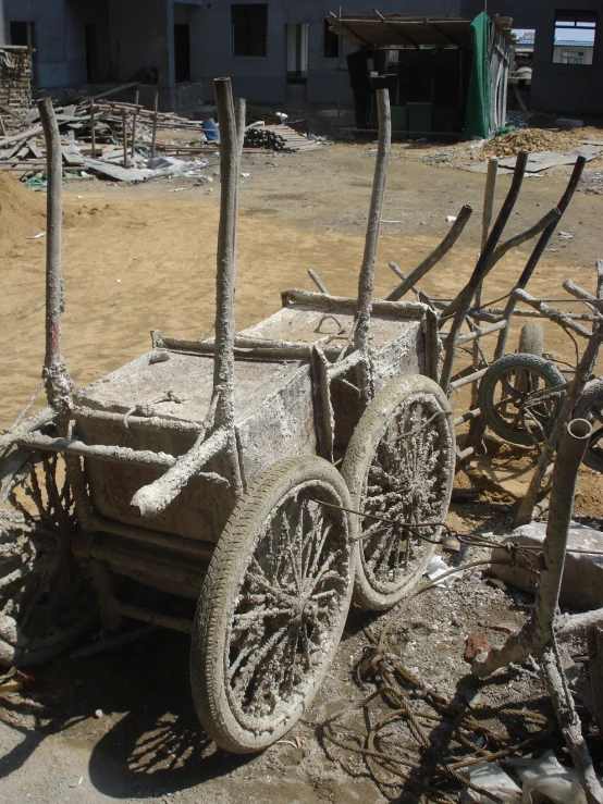 a group of old wooden cars sit in a dirt lot