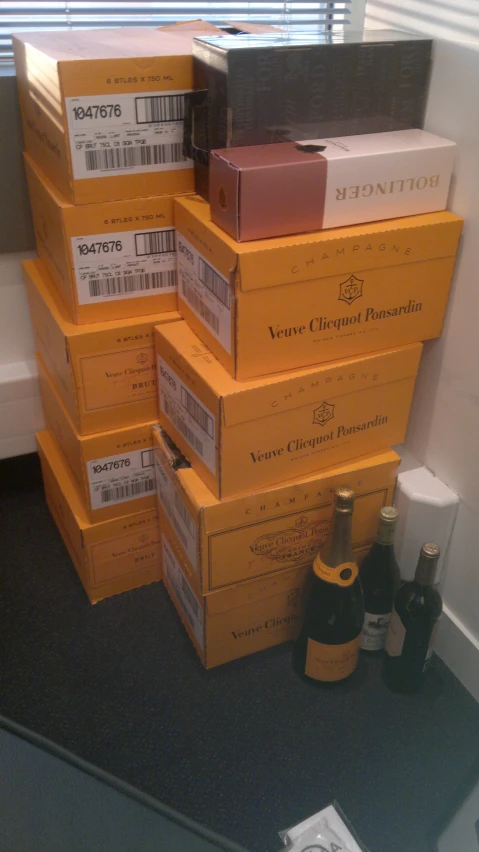 three wine bottles sit beside boxes of wine