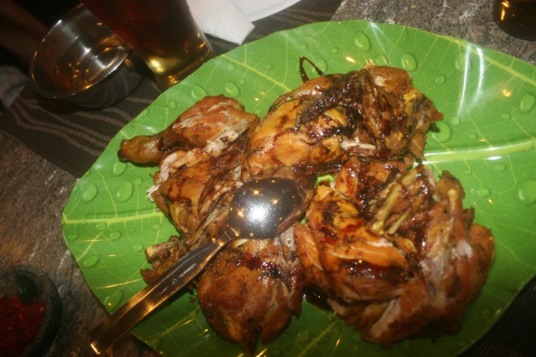 a green plate topped with chicken and sauce