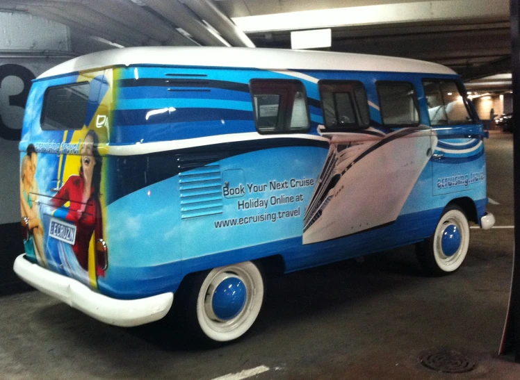 a blue and white vw van parked next to a parking space