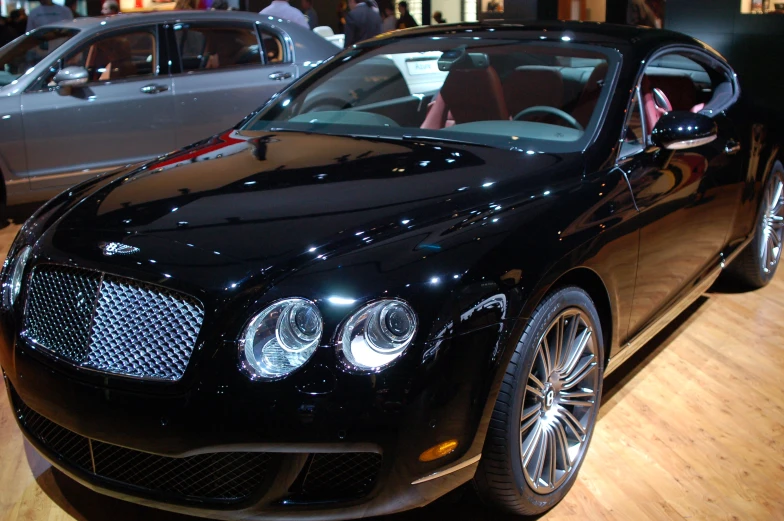 a black sports car at the booth of a car show