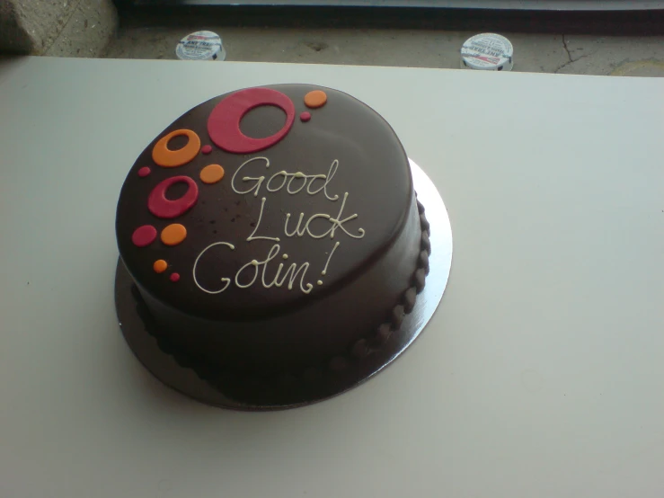 a chocolate birthday cake with frosting reading good luck going