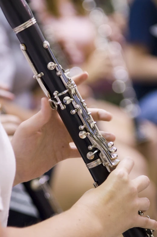 an orchestra member is playing a flute while people look on