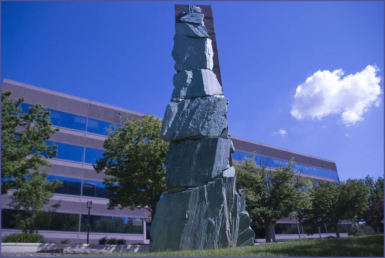 the sculpture is in front of the large building