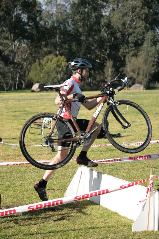 the person jumping over the grass with his bike