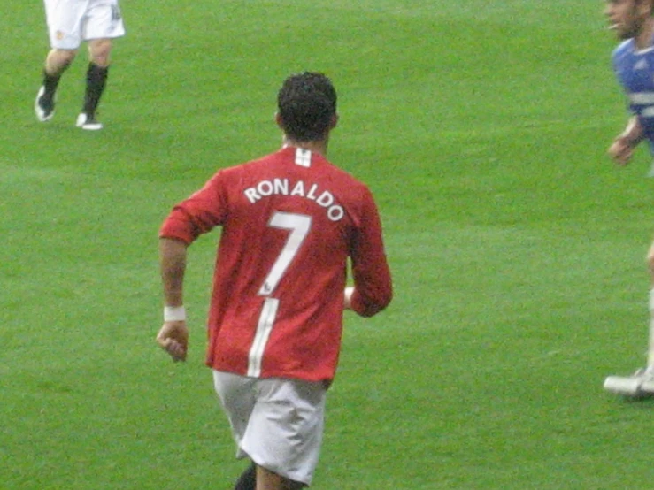 a man standing on top of a lush green soccer field