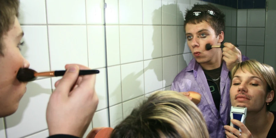 a woman brushing her teeth while two men look on