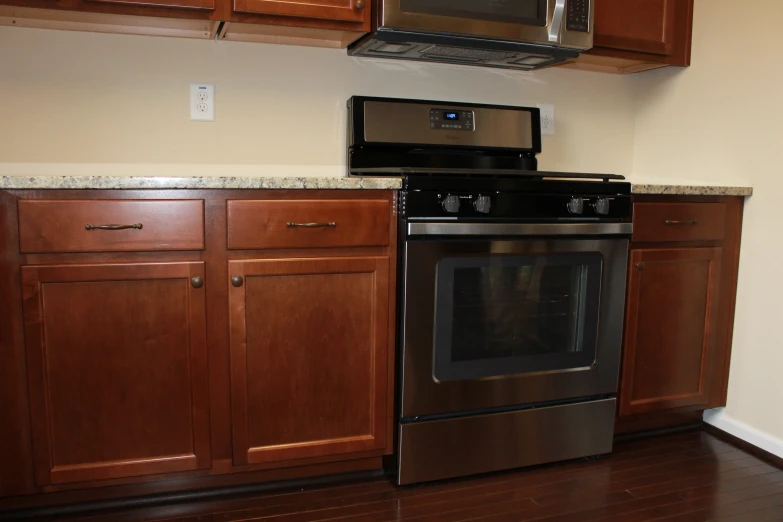 an empty kitchen with a stove and microwave