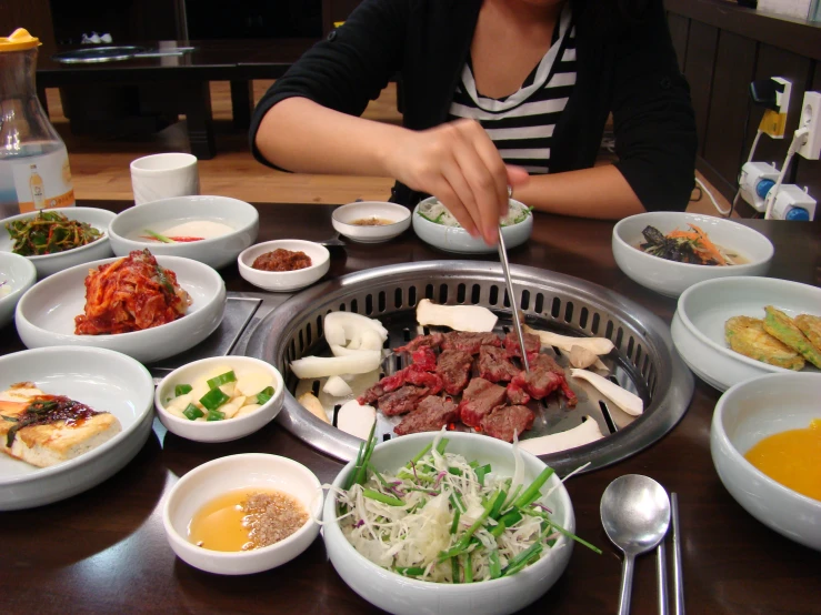 a woman sitting at a table with some food